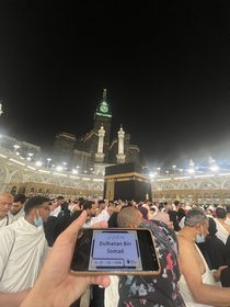 Bukti pelaksanaan badal haji, kartu jamaah ditunjukkan di depan Ka’bah